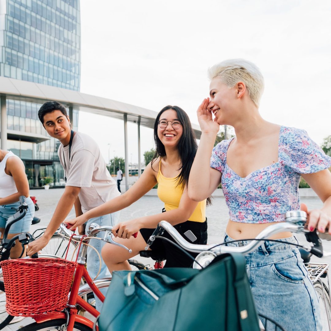 Group multiethnic friends outdoor riding bicycle