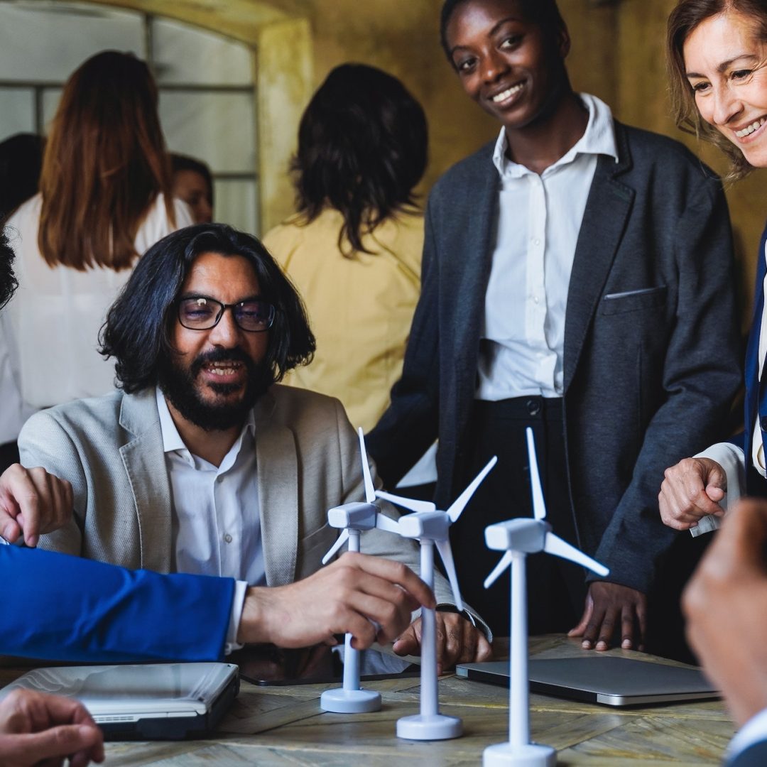 Happy business people work on sustainable renewable energy project inside office - Eco electricity